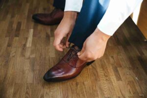 Groom Ties Laces His Shoes